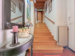 Stunning hallway with a console table, vase, and stained glass lamp, leading to a beautifully crafted staircase.