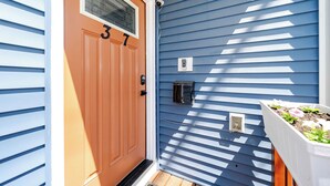A front door with a number plate, a mailbox, and a small garden planter. - Spacious Greater Boston Townhouse Near I-93 • Parking • Pet-Friendly | 37 (Quincy)