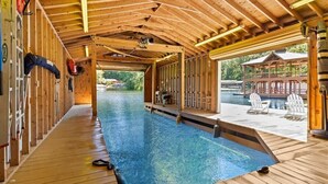 Une piscine intérieure en bois donnant sur un espace extérieur.