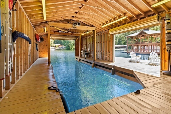 A wooden indoor pool with a view of an outdoor area.