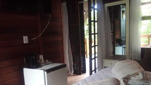 Une chambre avec un lit, un petit bureau blanc, un miroir et une fenêtre avec des rideaux.