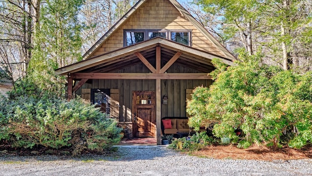 A wooden cabin with a gabled roof, a front porch, and a door with a window above it. - Heinrich - Mill Creek Cottage: Walk to Downtown | Creekside Retreat w/ Hot Tub (Highlands)