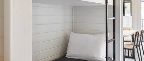 Una cama litera con estructura blanca y colchón gris.