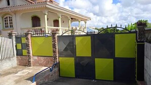 A gated entrance with a stone wall and a metal gate. - 5 Bedroom Villa in Le Lamentin (Le Lamentin)
