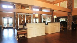 A spacious lobby with a reception desk, a fireplace, and a stone accent wall.