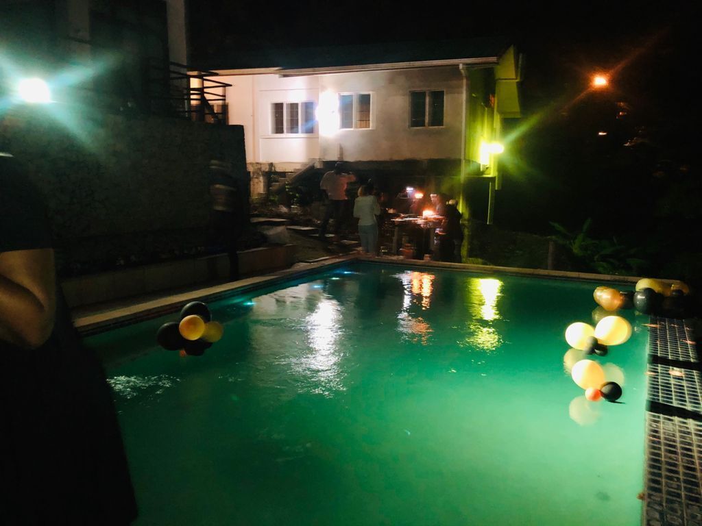 Une piscine entourée de personnes, de nuit.