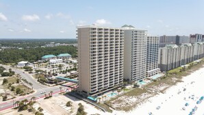 Ein Hochhaus-Hotel mit mehreren Balkonen, einem Pool und Blick auf den Strand.