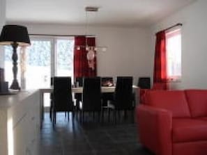 Relax in this stylish living room with a sofa and dining area, perfect for unwinding.