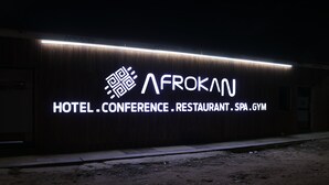 A building with a sign that reads 'AFROKAN HOTEL.CONFERENCE.RESTAURANT.SPA.GYM.'