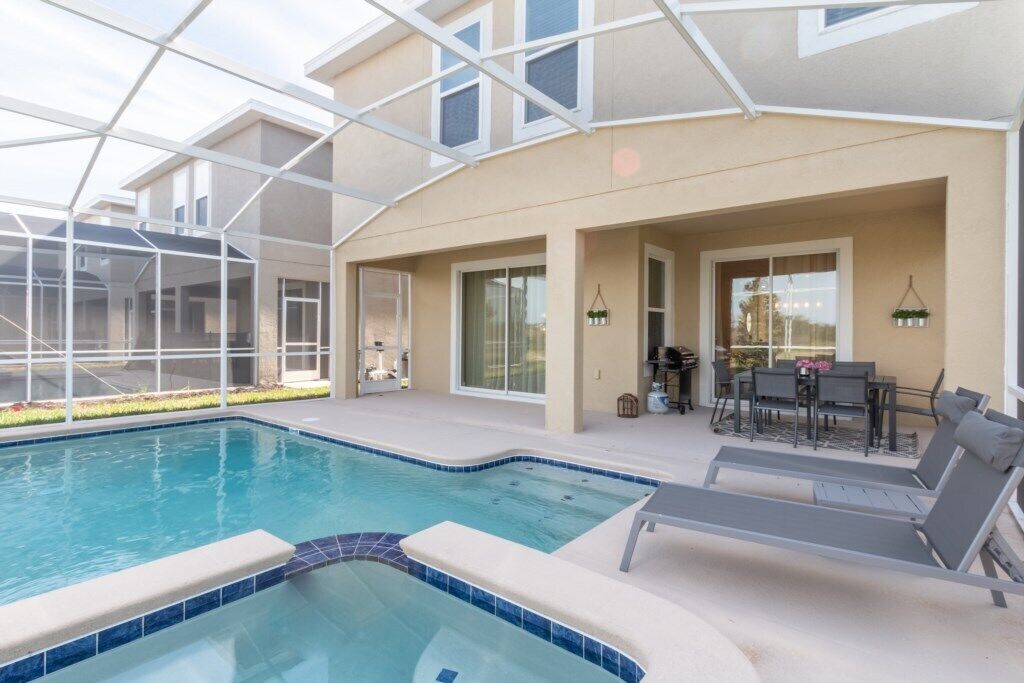 A swimming pool with lounge chairs and a patio area.