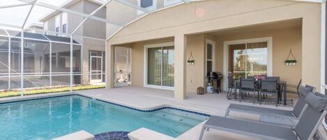 A swimming pool with lounge chairs and a patio area.