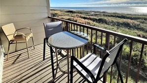 A balcony with a view of a beach and marshland. - Admiral’s Row 203: Romantic Oceanfront Retreat with Bunk Beds (Hilton Head Island)