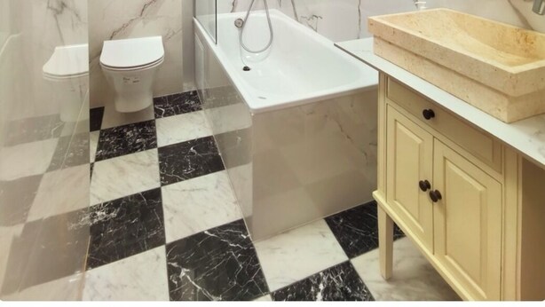 A modern bathroom with a toilet, bathtub, and vanity.