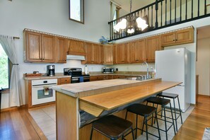 Prepare meals and dine in comfort at this kitchen with a spacious island, ample storage, and modern appliances.