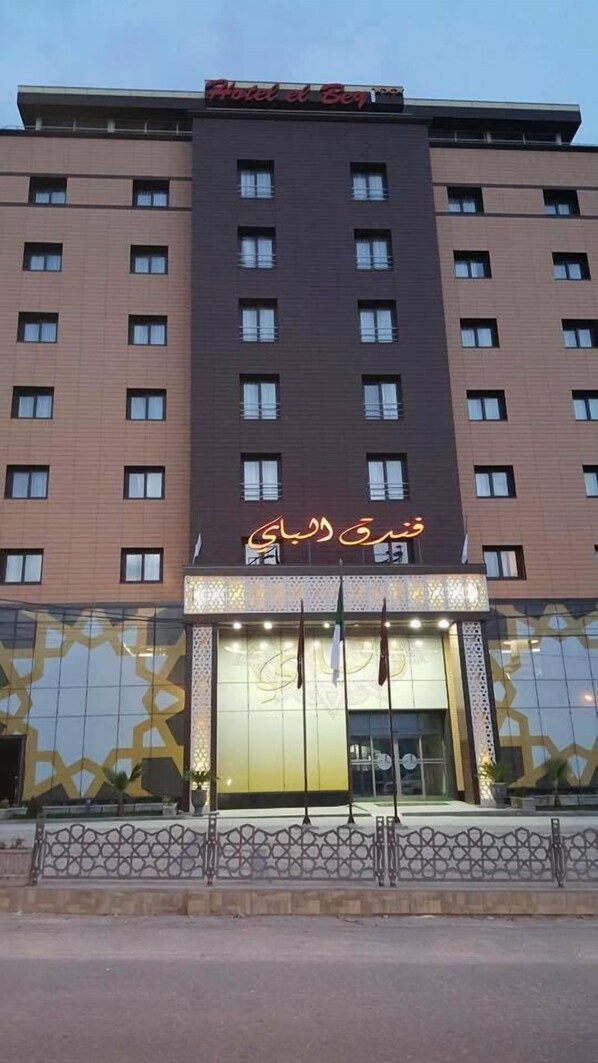 A hotel with a modern facade, multiple windows, and a prominent entrance with illuminated signage.
