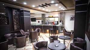 A modern lounge area with leather seating, a bar, and a coffee station. - Hotel Elbey Constantine (Constantine)