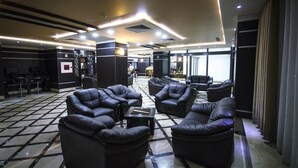 A lobby with leather sofas, a coffee table, and a tiled floor. - Hotel Elbey Constantine (Constantine)