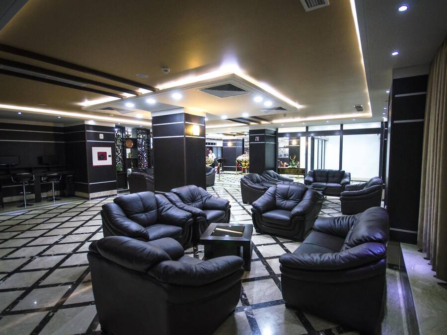 A lobby with leather sofas, a coffee table, and a tiled floor.
