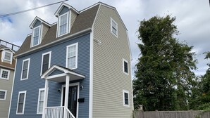 A two-story house with a front porch and a wooden fence. - Luxury modern house  off Thames Street (Newport)