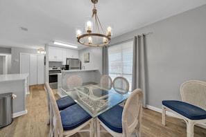 Enjoy meals in this dining area with a glass-top table and wicker chairs.