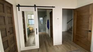 Ein Flur mit einer Schiebetür, Holzdielen und einem Teppich.
