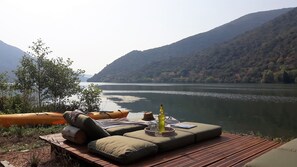 Un espacio de descanso junto al río, con vistas a un río y montañas.