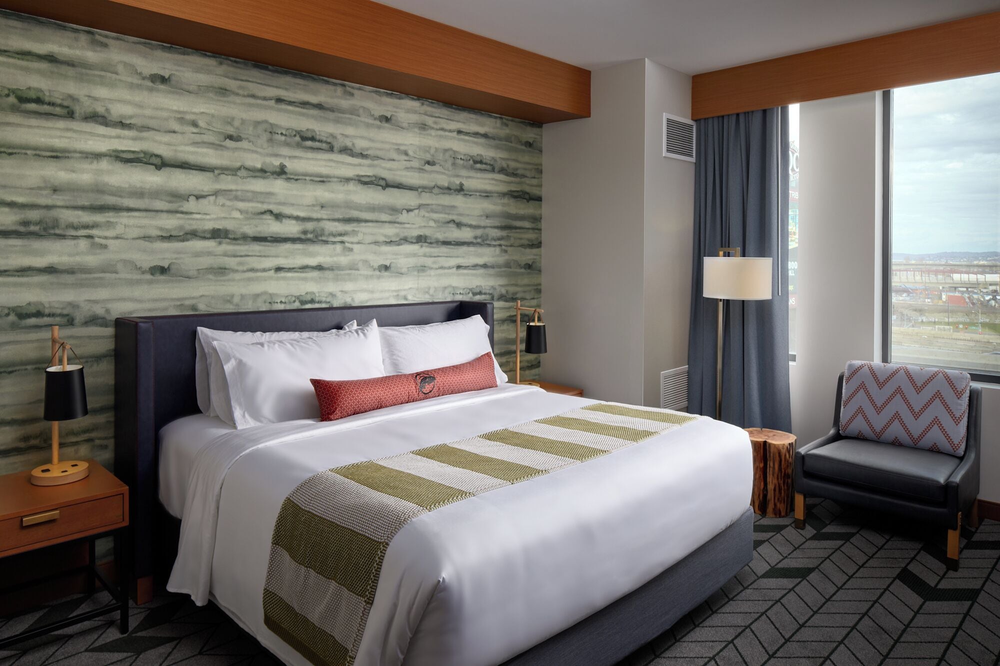 Une chambre d’hôtel dotée d’un grand lit, offrant une vue sur la ville et présentant un design moderne.