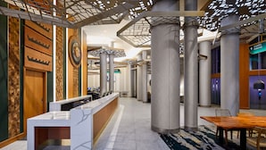 A modern hotel lobby with a reception desk, seating area, and a sign indicating the direction to the casino parking. - Emerald Queen Hotel and Casino - Tacoma (Tacoma)
