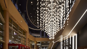 A spacious lobby with a central seating area, escalators, and a modern chandelier. - Emerald Queen Hotel and Casino - Tacoma (Tacoma)