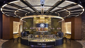 A modern cafe with a central display case, wooden accents, and a unique ceiling design. - Emerald Queen Hotel and Casino - Tacoma (Tacoma)
