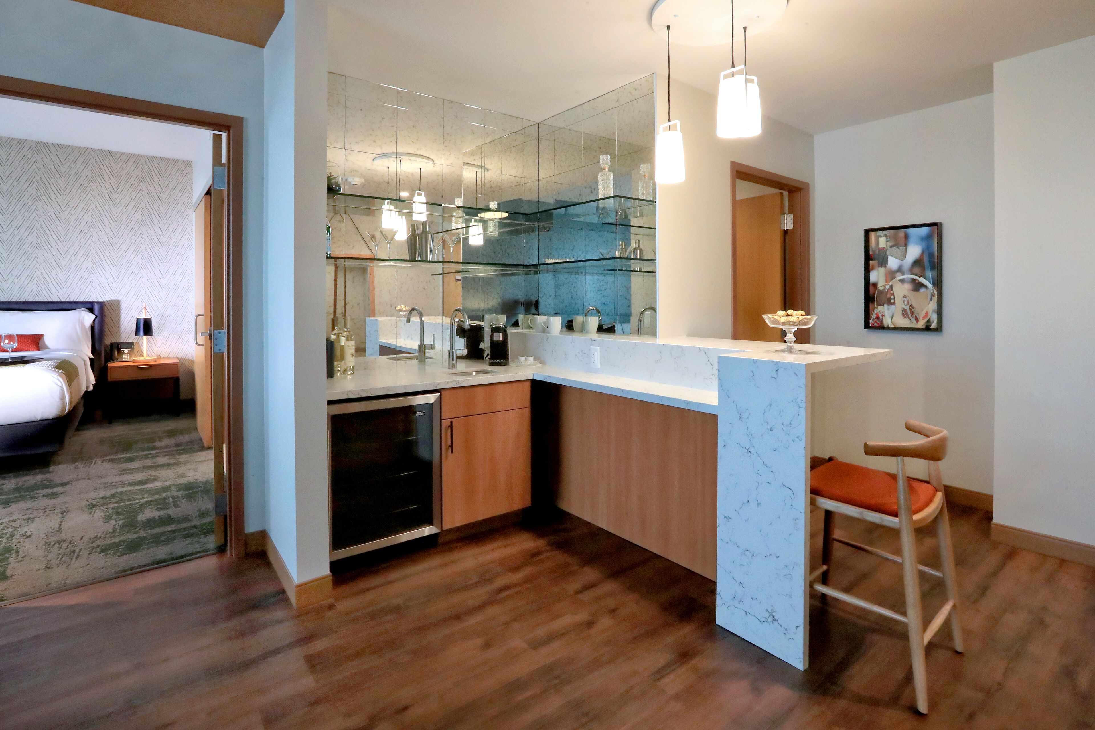 Una cocina moderna con una isla grande, armarios de madera y un salpicadero de vidrio.