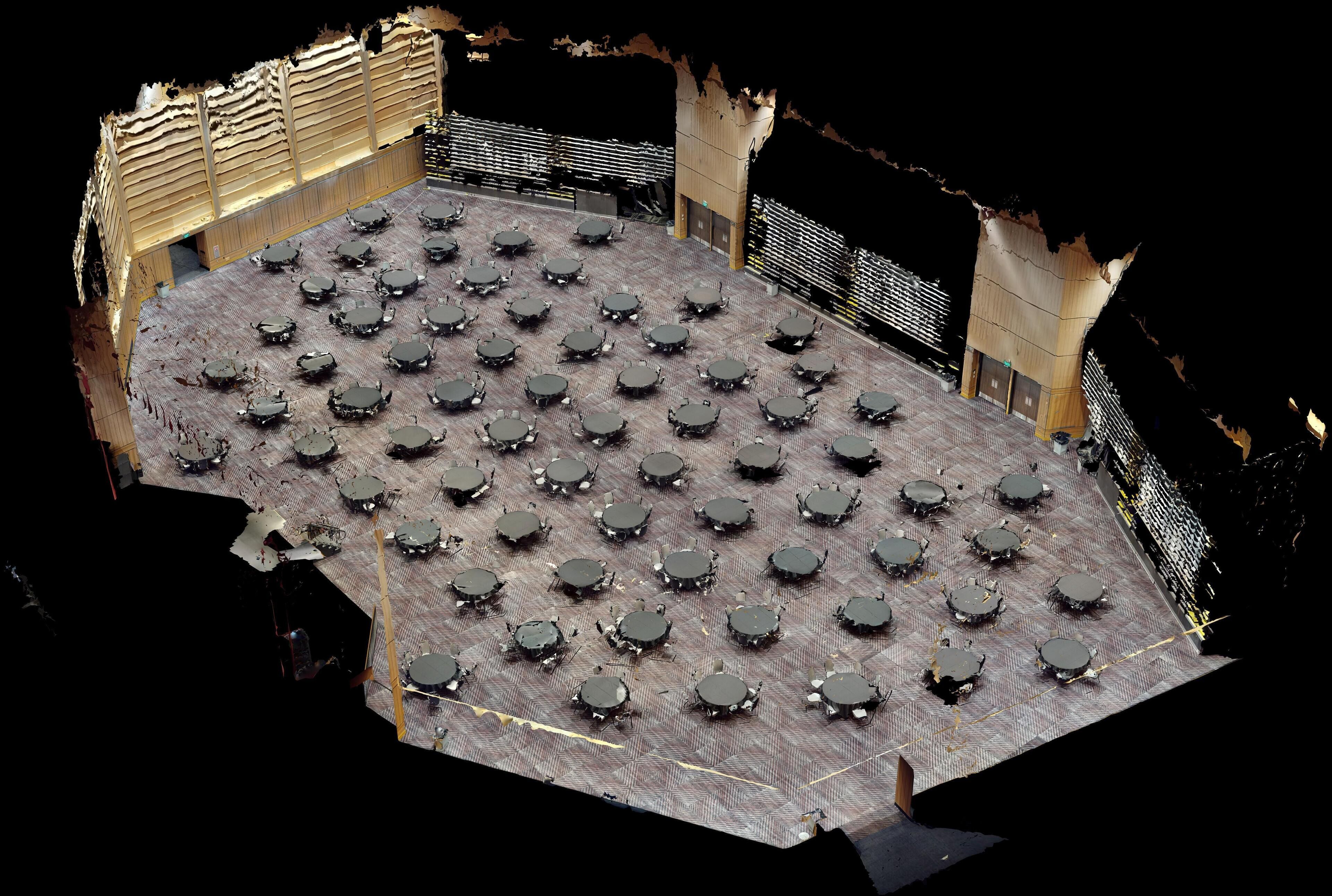 A large, open-plan area with numerous tables and chairs arranged in a grid pattern, likely a dining or meeting space.