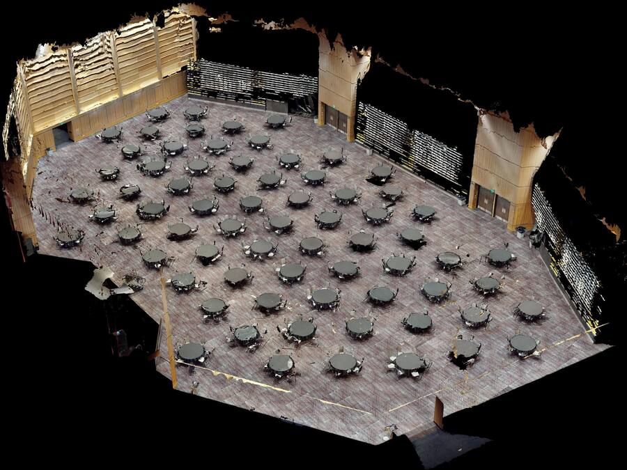 A large, open-plan area with numerous tables and chairs arranged in a grid pattern, likely a dining or meeting space.