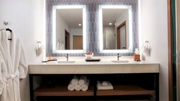 A bathroom with two sinks, a large mirror, and a towel rack.