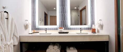 A bathroom with two sinks, a large mirror, and a towel rack.