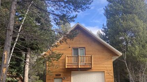 A log cabin with a balcony, a garage, and a door. - Quiet and clean cabin near Yellowstone National Park (Island Park)