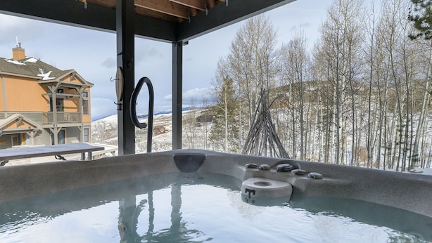 Ein Whirlpool mit Blick auf ein Haus und Bäume.