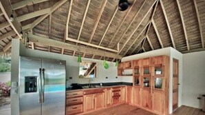 Una cocina amplia con armarios de madera, un refrigerador de acero inoxidable y techo de madera.