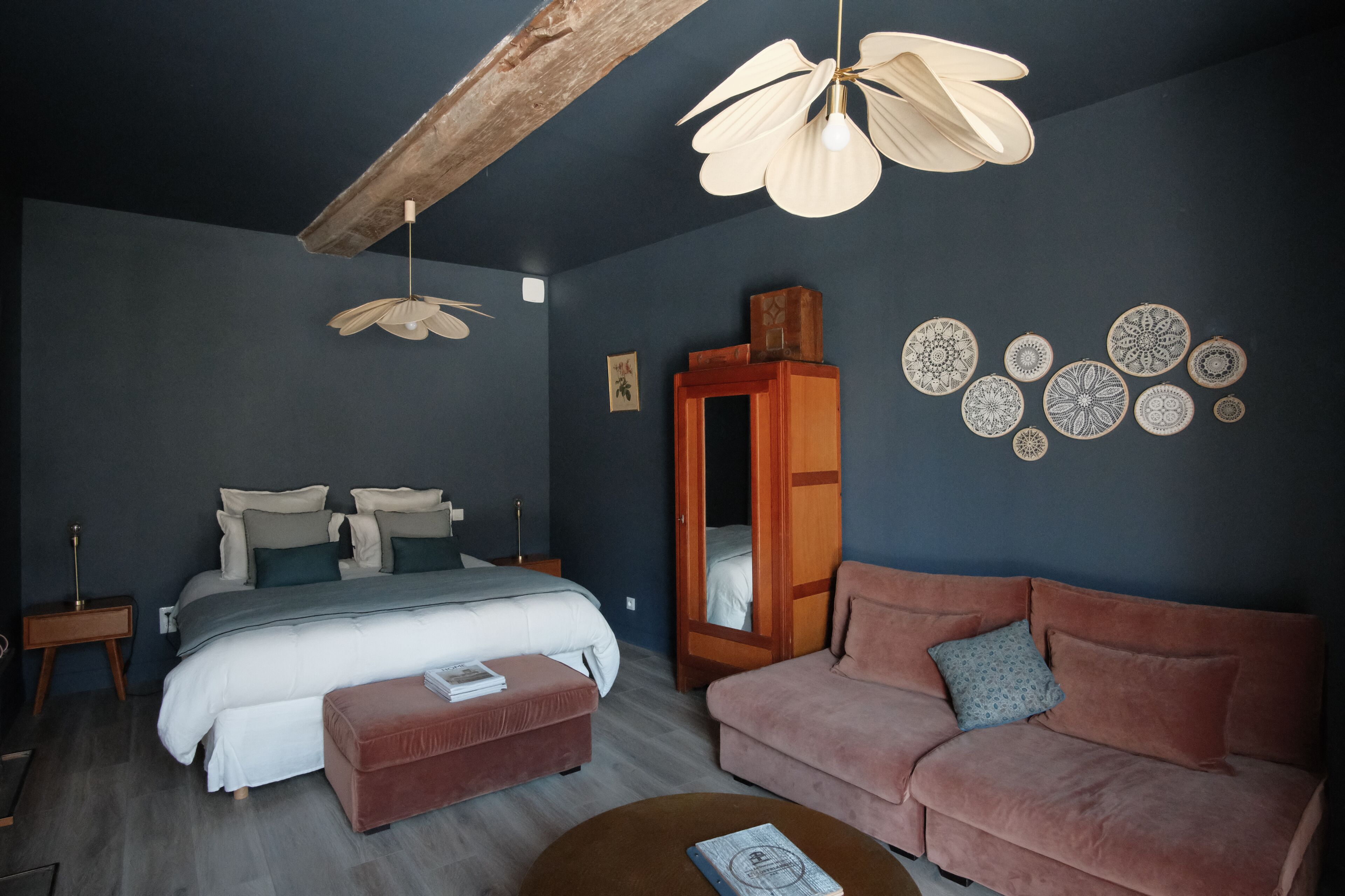 Un dormitorio con cama, sofá, una mesita de centro y ventilador de techo.