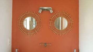 A bathroom with two sinks, a mirror, and a towel dispenser.