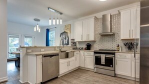 Una cocina moderna con armarios blancos, electrodomésticos de acero inoxidable y una isla grande.