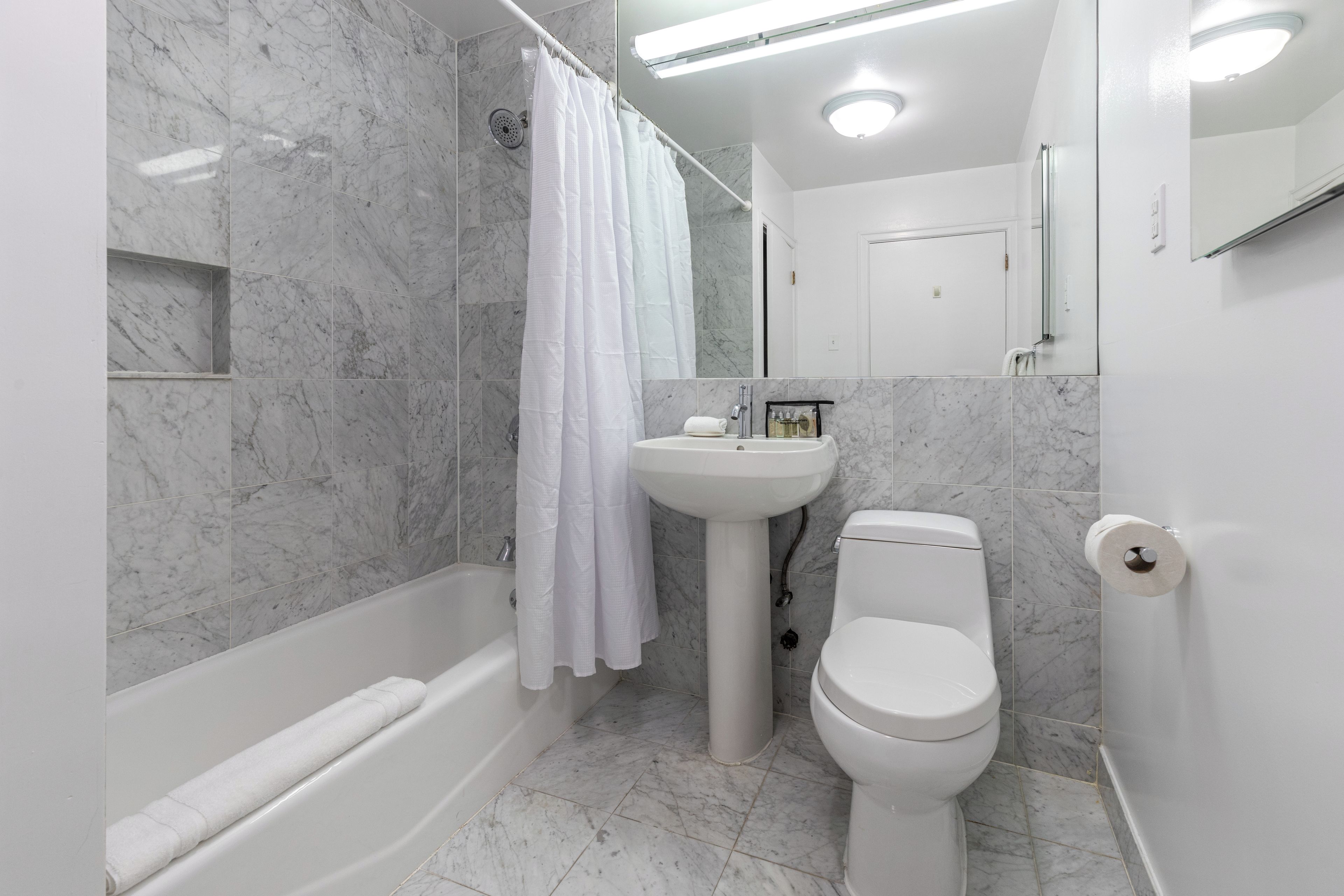 A modern bathroom with a bathtub, a sink, and a toilet.