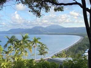 A coastal landscape with a beach, palm trees, and mountains in the background. - Entire 2 bed townhouse, your home away from home (Port Douglas)