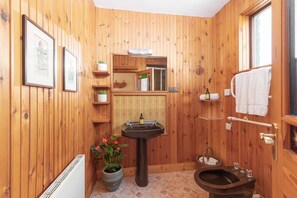 A wooden-paneled bathroom with a sink, toilet, and towel rack. - Wood Quay 3 bedroom house (Dingle)