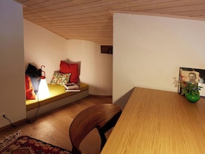 A room with a wooden ceiling, a bed with a red pillow, a small table with a green vase, and a chair. - Am Dürrbach 2/244 Appartement/Fewo 6-Bettwohnung by Interhome (Engelberg)