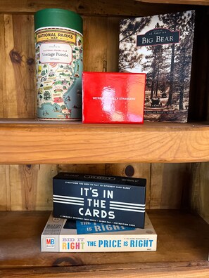 A shelf with a National Parks Map puzzle, a book titled 'Big Bear', and a card game box.