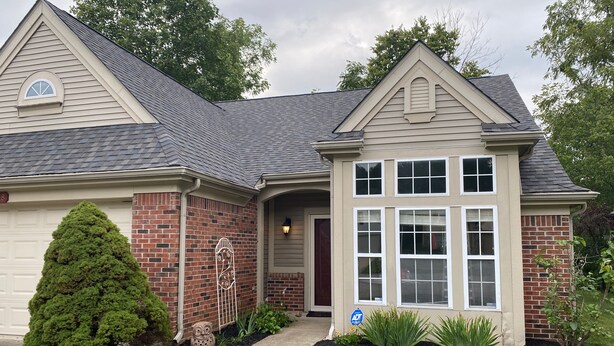 A two-story house with a brick facade, a large front window, and a well-maintained lawn. - Quiet 3BR Home near IU Campus - Perfect for Game Days, Lotus, Events & Families (Bloomington)
