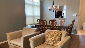 A dining area with a wooden table and chairs, a chandelier, and a potted plant. - Quiet 3BR Home near IU Campus - Perfect for Game Days, Lotus, Events & Families (Bloomington)