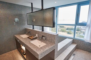 Une salle de bain moderne avec deux lavabos, un grand miroir et une vue sur le paysage grâce à une grande fenêtre.