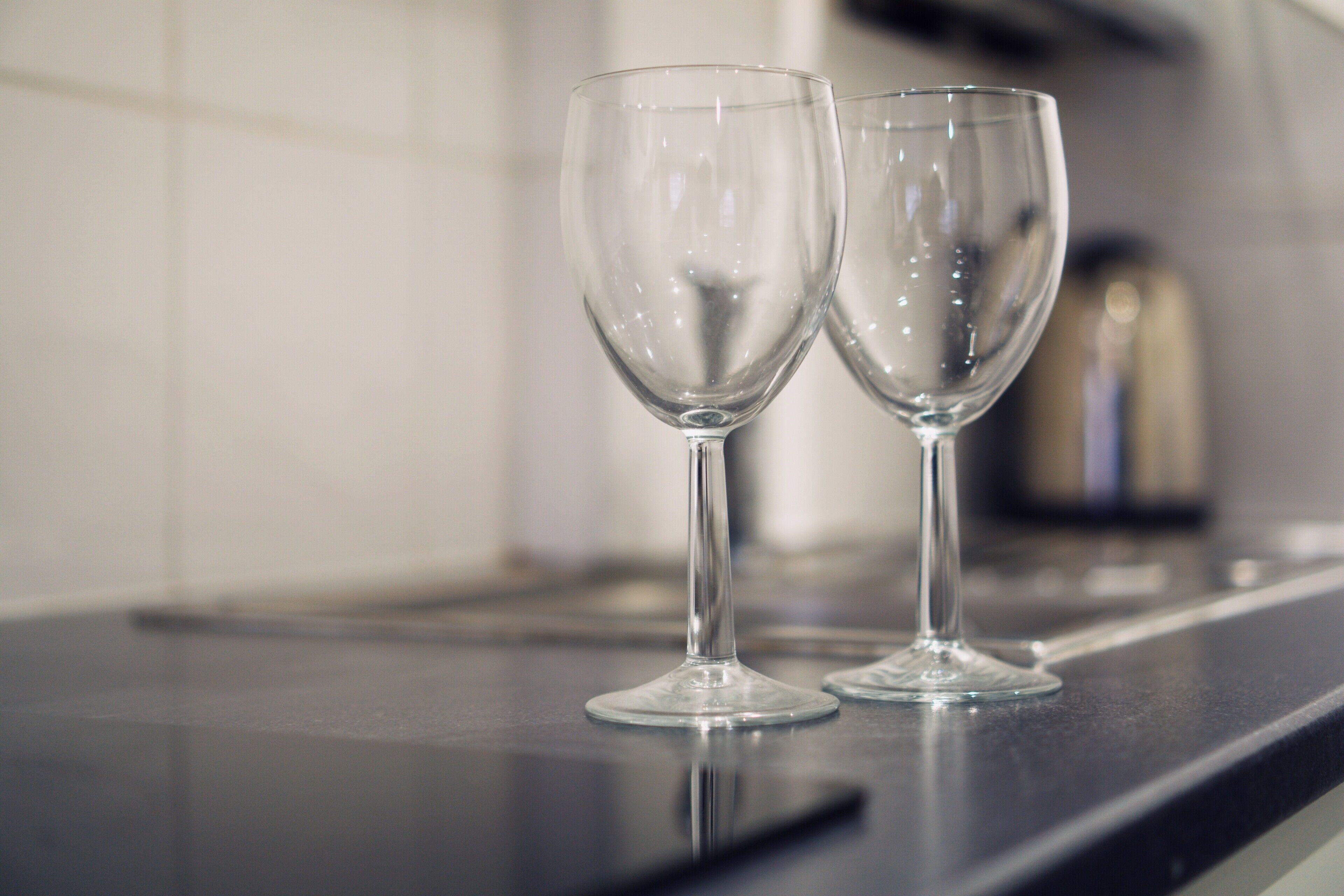 Two empty wine glasses on a kitchen counter.